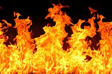 This image showcases a close-up of fierce, blazing fire against a dark background, capturing the natural dance and dynamic motion of flames. The vibrant colors and intricate patterns offer a