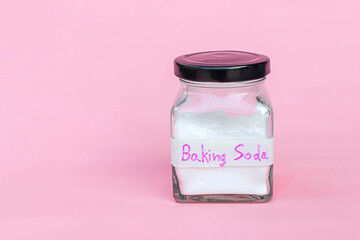 Jar of baking soda isolated on pink background