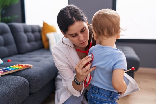 Mother and son doctor examining child at home