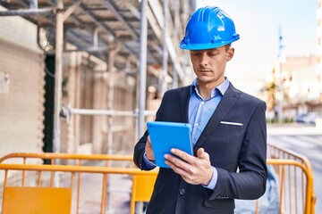 Young man architect using touchpad at street