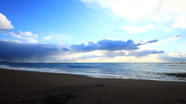 砂浜に打ち寄せる海の波　青空