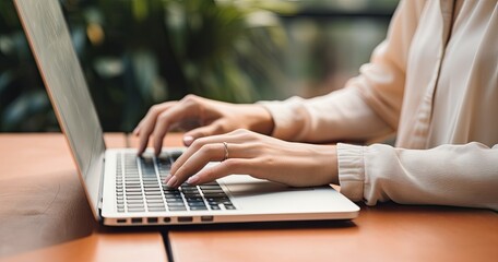 In a office setting, a desk is adorned with a laptop, and hands are actively typing away. Whether engaged in remote work, conducting internet searches, or managing a blog, close-up scene.