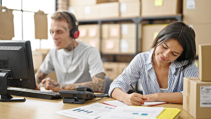 Fototapeta premium Two ecommerce business workers working together at office