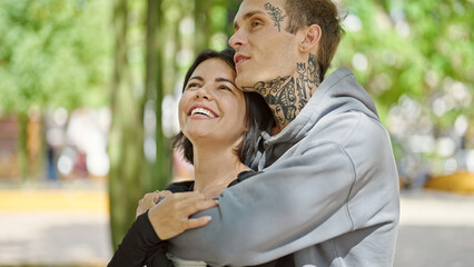 Beautiful couple smiling confident hugging each other at park