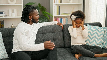 African american father and daughter sitting on sofa arguing at home