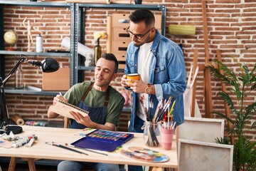 Two men artists drawing on notebook drinking coffee at art studio