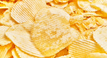 Close-up of crisp, textured potato chips piled together, emphasizing the concept of snacking and indulgence.