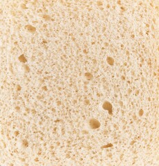 Close-up texture of a slice of white bread, showing the porous surface and air bubbles.