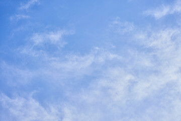 A serene sky scene with fluffy white clouds floating against a bright blue backdrop, epitomizing tranquility and open space.