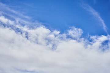 A serene sky dotted with fluffy clouds and streaks of white, symbolizing tranquility and vastness.