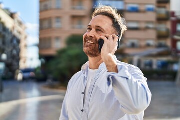 Young caucasian man smiling confident talking on the smartphone at street