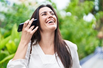 Young beautiful hispanic woman smiling confident listening audio message by the smartphone at park