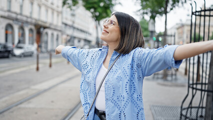 Obraz premium Young beautiful hispanic woman with open arms in the streets of Vienna