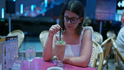 Gorgeous hispanic woman, delighting in a smooth, creamy milkshake at kabukicho, tokyo's business hub