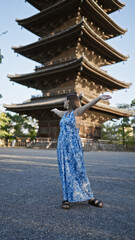 Cheerful brunette hispanic woman welcoming joy with open arms, looking around beautiful to-ji temple, reveling in kyoto's tower beauty