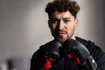 Man with red boxing gloves training at home