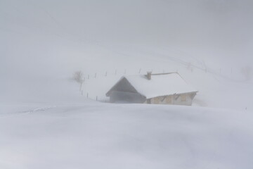 chalet enneigé dans la brume. vallée de Bellevaux. Haute Savoie. Alpes