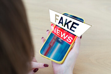 A woman watches fake news on her smartphone. Concept of false news in the media