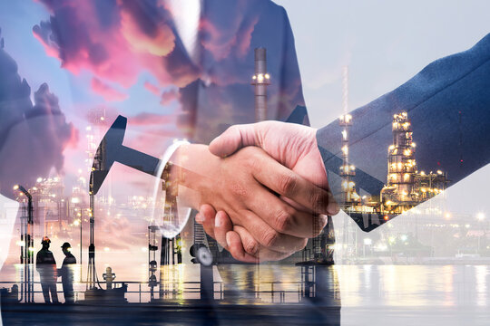 Double exposure of businessman handshake with Crude Oil pump oil rig energy industrial machine for petroleum background