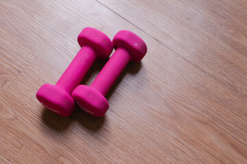 dumbbells with plastic coating on a wooden background