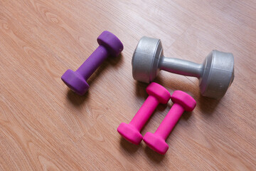 dumbbells with plastic coating on a wooden background