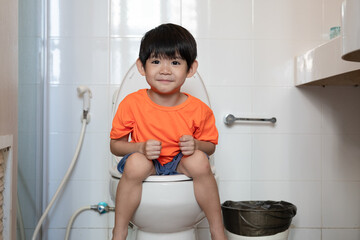 Asian boy Sitting on the toilet bowl