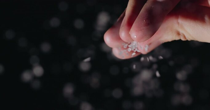 Chef pours salt, close-up low angle shot. Slow motion video