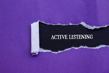 Active listening words written on purple torn paper with black background. Conceptual symbol. Copy...