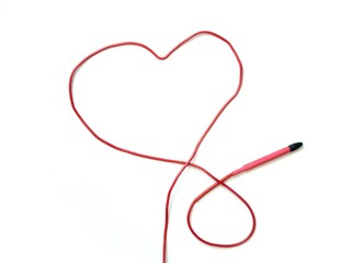 The red handle of the electric epilator on a white artificial leather wire in the shape of a heart...