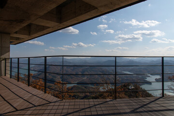 View of metal guardrail against mountains and clouds in autumn