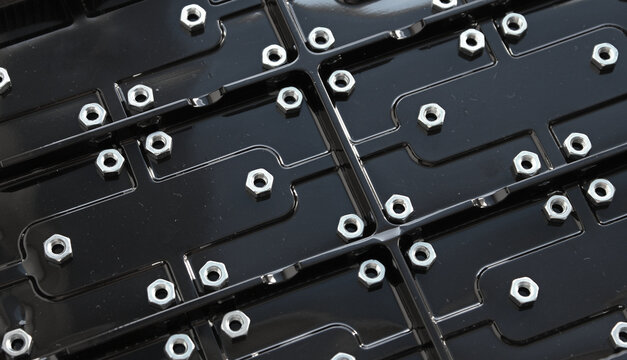 Abstract background of black corrugated plastic panel with iron hex huts  
