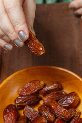 A Muslim woman's hand at the table takes a date during Ramadan Iftar