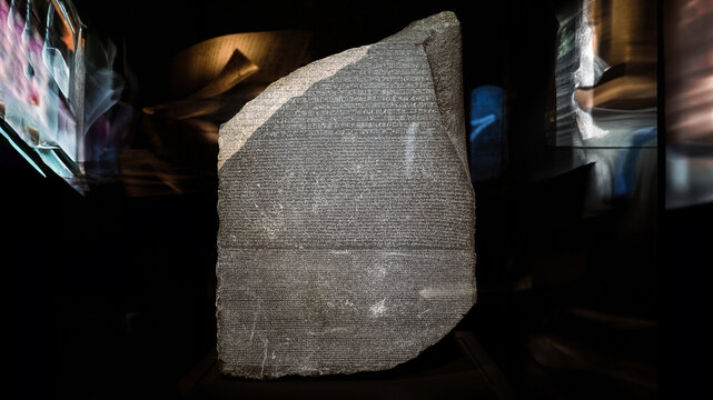 London, UK - December 10 2022 : Close up detail of the Rosetta Stone in the briths museum. This fragment of an ancient stela (an inscribed slab), most famous rock in world. 