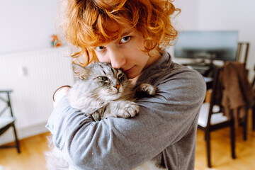 Portrait red-haired curly young woman with beloved fluffy domestic cat