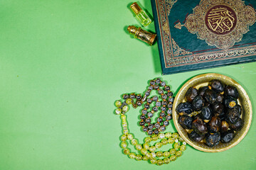 muslim book with arabic calligraphy Quran translation : holy book of Muslims and oud perfume and censer, dates fruit, tasbih. iftar ramadan concept