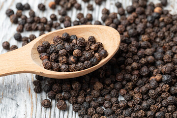 black pepper on wooden spoon