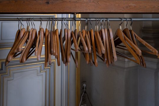 des cintres en bois vides sur un portant &agrave; vetement dans un vestiaire.