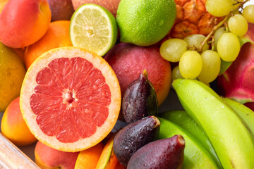 Closeup view of basket full of fresh mixed ripe colorful fruit. Tropical, seasonal, healthy eating concept