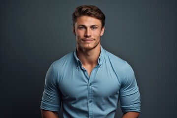 Obraz premium A man wearing a blue shirt strikes a pose while posing for a picture.