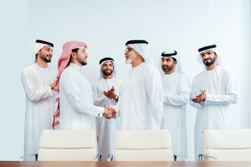Group of corporate arab businessmen meeting in the office - Business people wearing emirati clothing  working in the office - 733263913