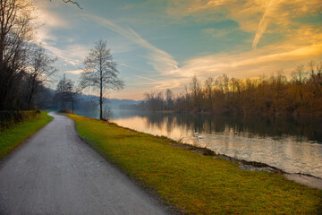 Cycle path along the river at sunset - obrazy, fototapety, plakaty