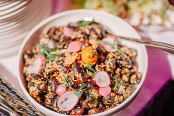 Sigulda, Latvia - January 12, 2024 - A close-up of a grain salad with herbs, radishes, and cherry tomatoes.
