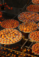 The artificial persimmons decorated on the rattan round tray
