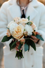 Wedding details. Close up of female hands holding bridal bouquet. winter wedding