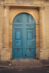 Fototapeta na wymiar Old fashioned front door entrance, white facade and blue door, Paris, France