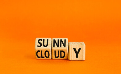 Sunny or cloudy symbol. Concept word Sunny or Cloudy on wooden cubes. Beautiful orange table orange background. Business lifestyle and sunny or cloudy concept. Copy space.