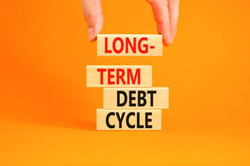 Long-term debt cycle symbol. Concept words Long-term debt cycle on beautiful wooden block. Beautiful orange table orange background. Businessman hand. Business Long-term debt cycle concept. Copy space