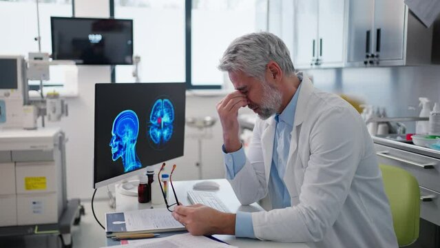 Sad doctor looks at an MRI scan, patient's bad test results, feeling helpless. Recurrence of the disease
