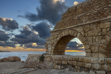 Aqueduct built by the Romans against the sky at sunset in Caesarea Israel