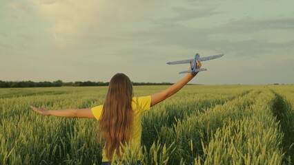 Child girl playing with toy plane. Teenager Girl dreams of flying, becoming pilot, and astronaut,...